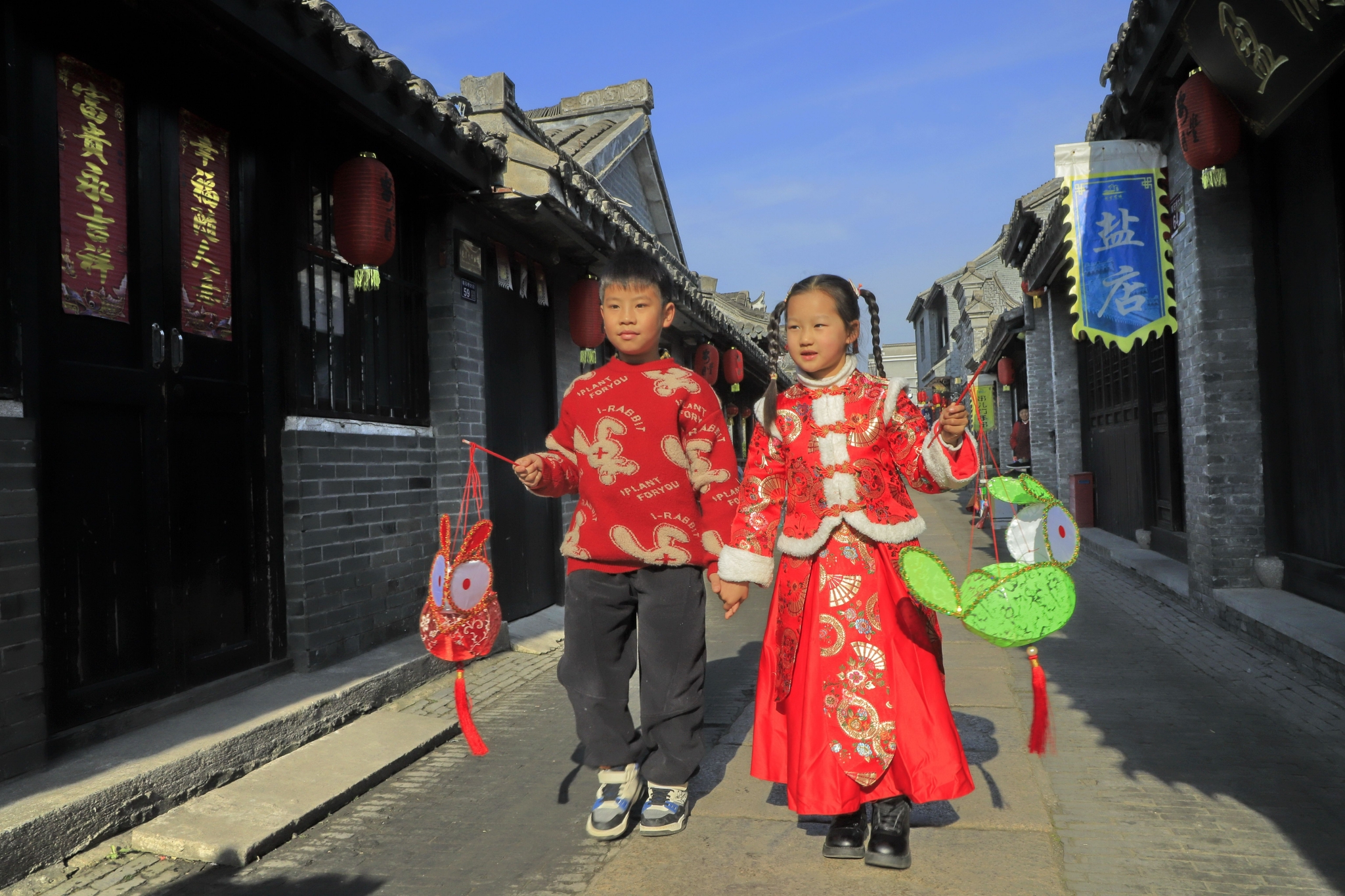 小朋友提着花灯在江苏省东台市安丰古街玩耍.通讯员 练益华 摄