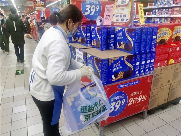 图为年货节期间，超市工作人员对京东到家订单中的亿滋礼盒拣货