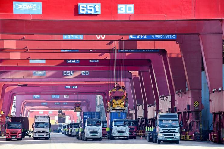 1月27日，在青岛港前湾集装箱码头，货车排队运送集装箱。（新华社记者李紫恒摄）