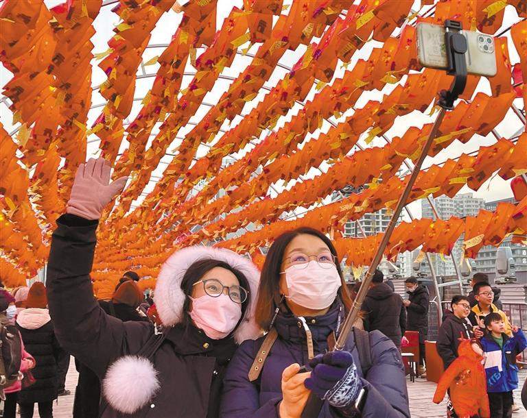 1月23日，游客在节日装饰物前拍照留念。