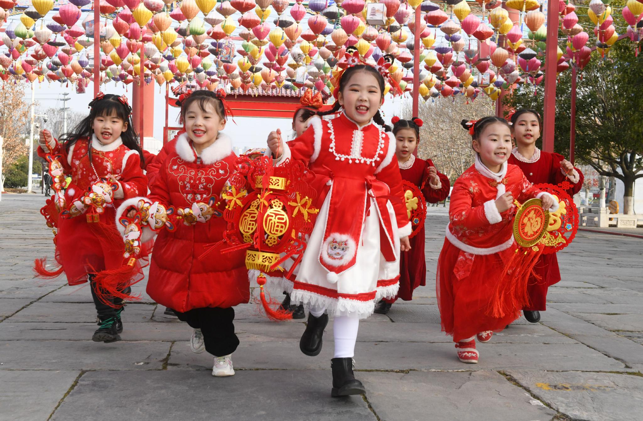 孩子们身穿喜庆服饰，手拿红灯笼、卡通兔以及“福”字等，喜迎新春佳节到来，感受传统节日气氛。通讯员 王彪 摄