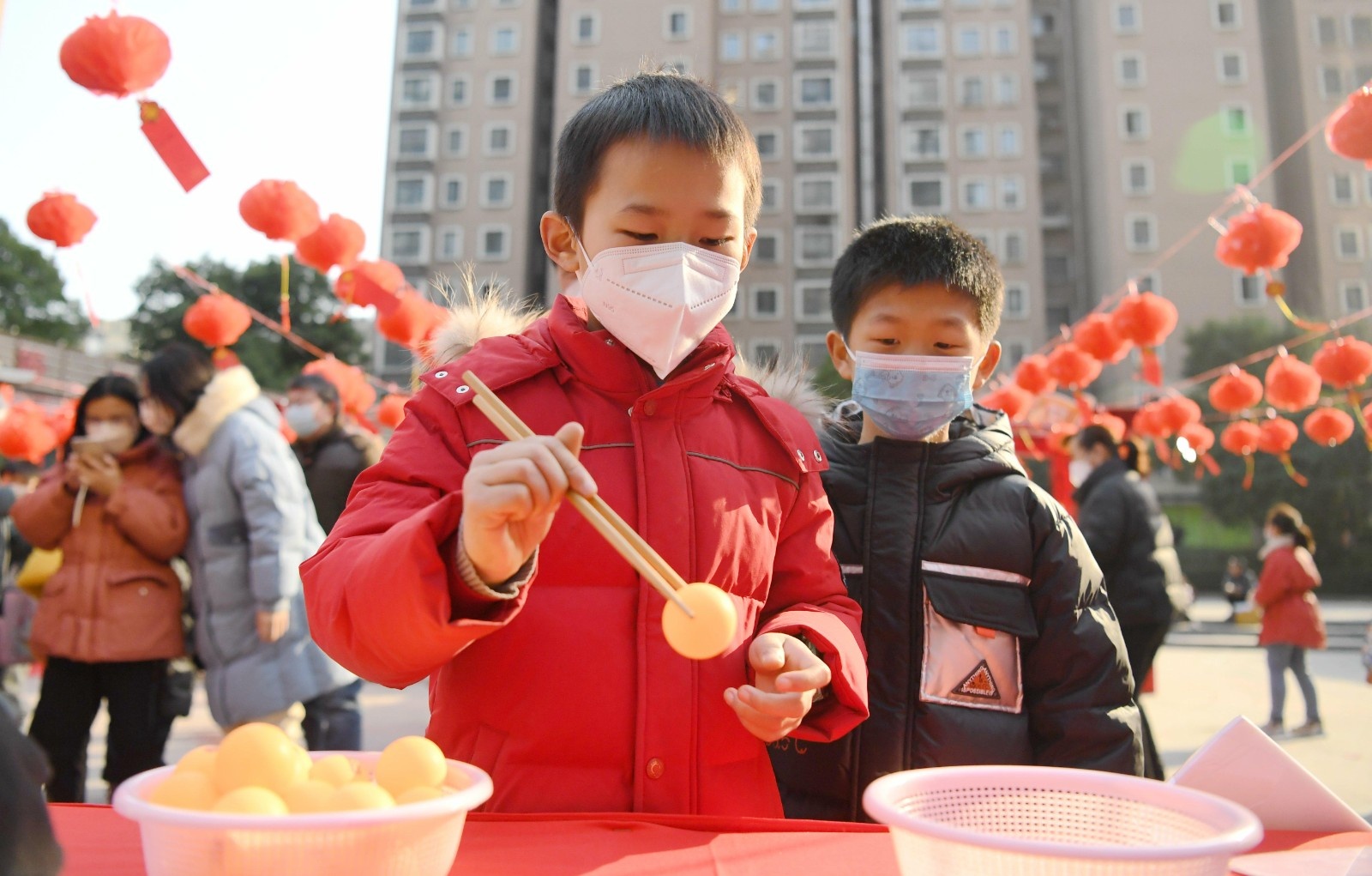 小朋友在体验夹乒乓球游戏.