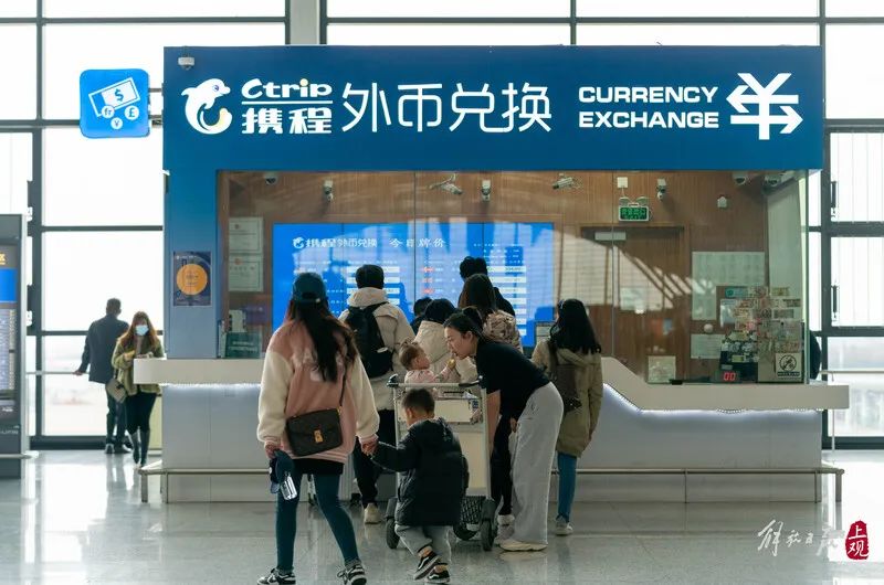 浦东机场外币兑换柜台前,游客在排队兑换.孟雨涵 摄