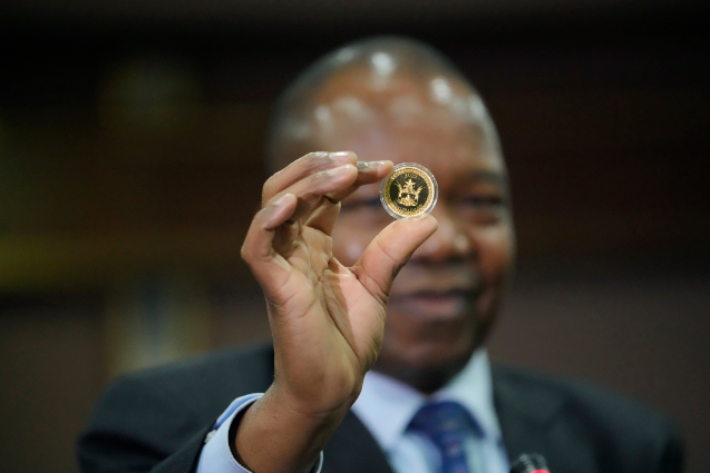 当地时间2022年7月25日，津巴布韦哈拉雷，储备银行行长约翰·曼古迪亚在发行仪式上手持金币样本。津巴布韦发行了面向公众出售的金币，以遏制失控的通货膨胀。（图片来源：视觉中国-VCG111393553298）