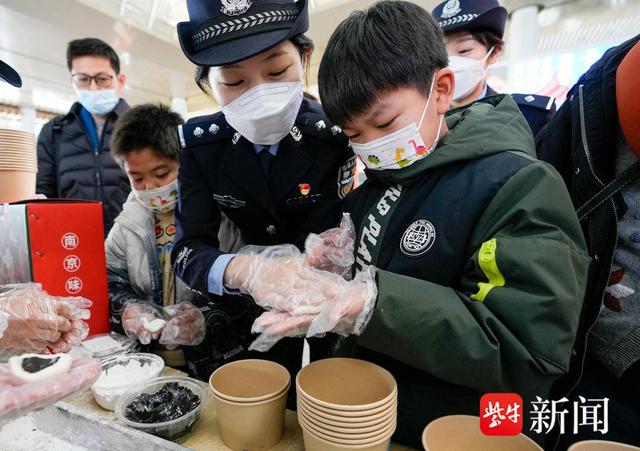 图为南京铁警跟旅客同庆元宵