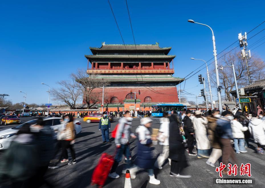 2月1日，市民游客经过北京市中轴线上的鼓楼的南侧过街人行横道。 中新社记者 侯宇 摄