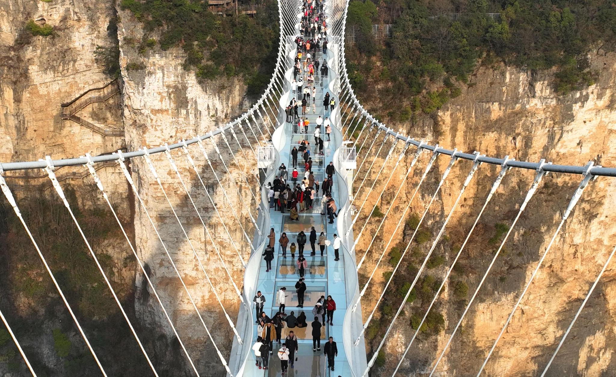 ▲2023年1月27日，游客在张家界大峡谷玻璃桥游览。春节期间，湖南张家界等风景名胜区连续迎来客流高峰。图/新华社