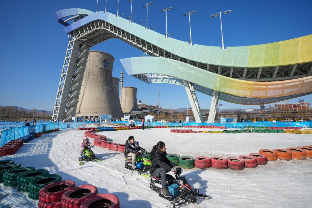 1月31日，游客在首钢滑雪大跳台下的“首钢园冰雪汇”体验雪上游乐项目。新华社记者鞠焕宗摄