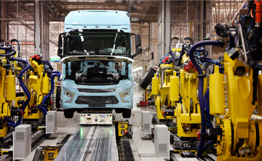 在陕汽重卡扩能项目现场,一辆重卡在汽车总装生产线轮胎自动化装配