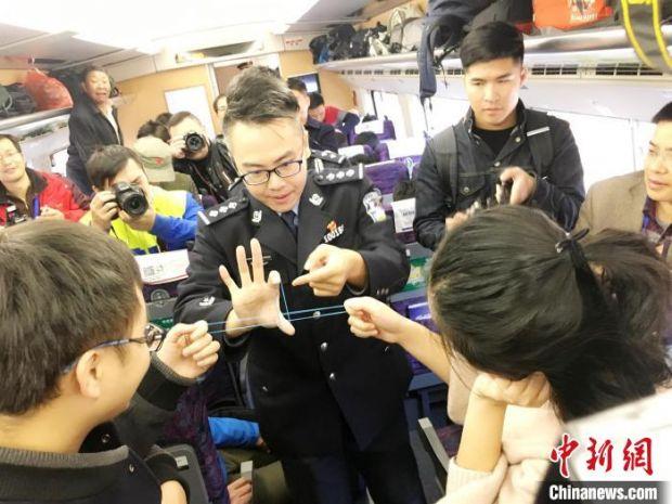 秦国平在列车车厢与旅客进行魔术互动。　 胡宏 摄