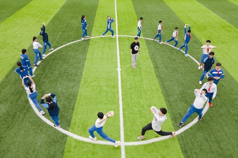 图:华海双语学校的体育课上,学生绕圈拉伸.