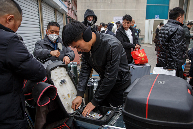 返京的外卖小哥为自己的坐骑换上电池。新京报记者 郑新洽 摄