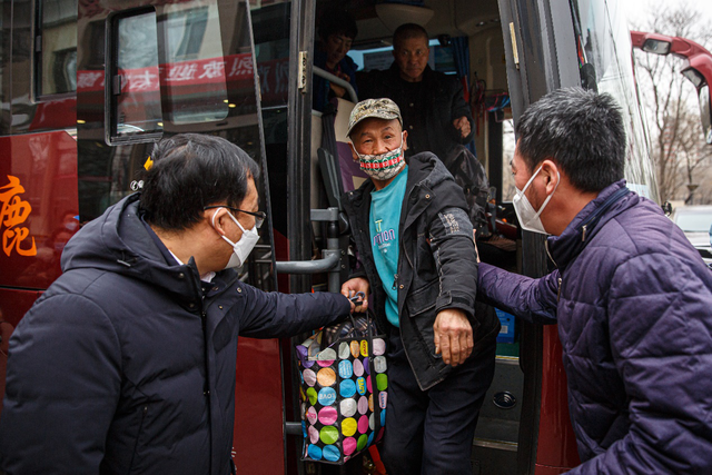 返京务工人员抵京下车，海淀区人社局工作人员上前迎接。新京报记者 郑新洽 摄