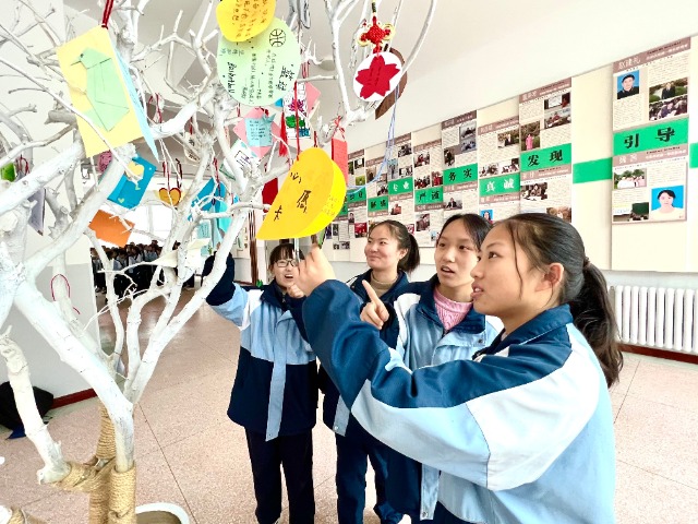 学生们将自己精心制作的心愿卡挂到心愿树上.郑芃生 摄