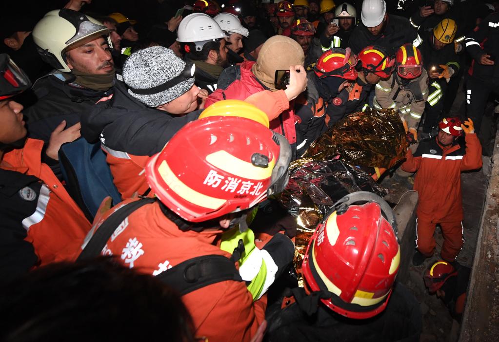 2月9日晚，在土耳其哈塔伊省安塔基亚市，中国救援队与土耳其救援队合力营救出的幸存者被抬出废墟。新华社记者沙达提摄