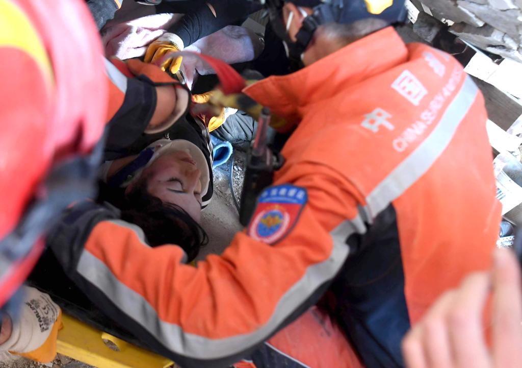 2月9日，在土耳其哈塔伊省安塔基亚市，中国救援队与土耳其救援队转移一名救出的女性幸存者。新华社记者沙达提摄
