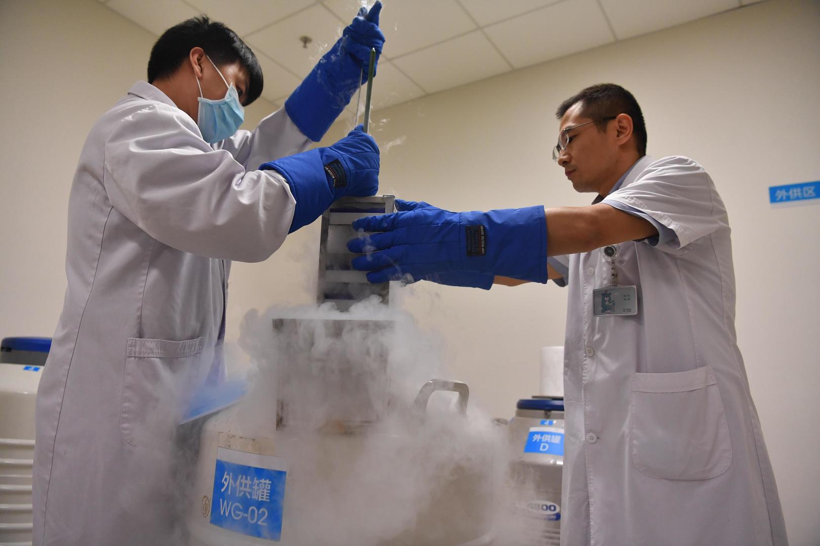 ↑工作人员在操作储存精子的液氮罐 据视觉中国