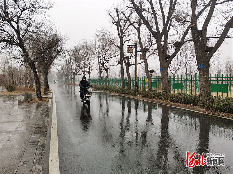 在沧州市大运河堤顶路,雨夹雪天气中,路面变得湿滑.