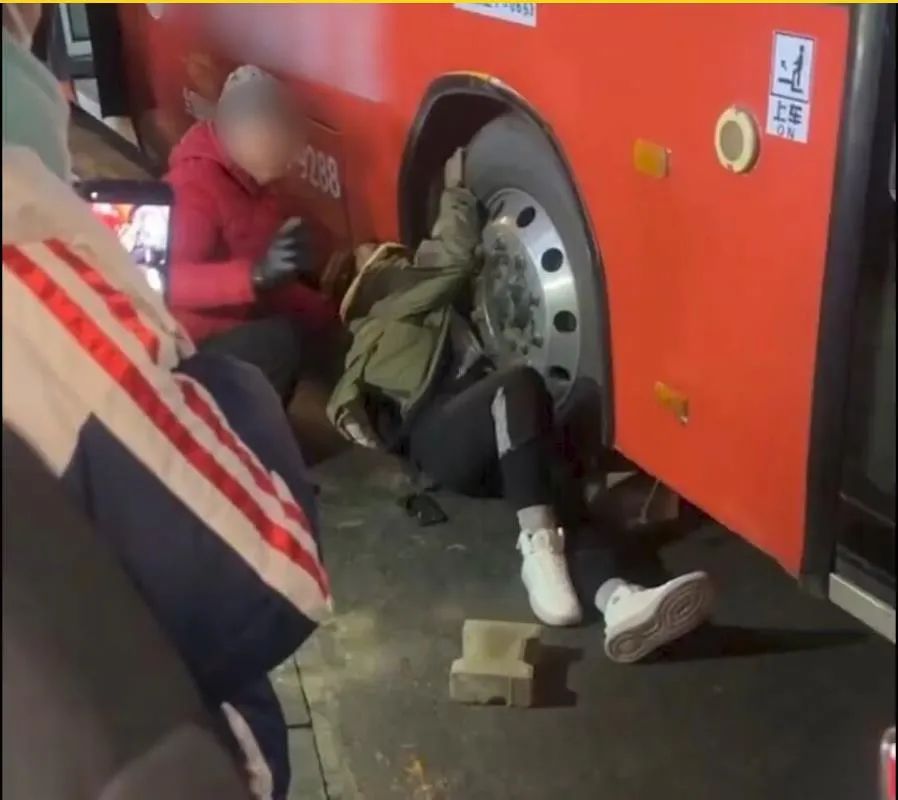 女孩被卷入公交车底。现场视频截图