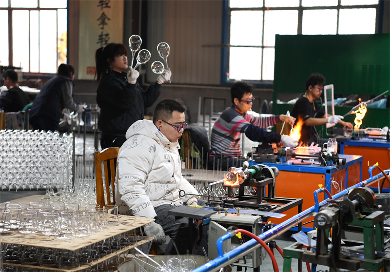 2月11日,河北省河間市一家工藝玻璃製品生產企業工人在車間內加工產品