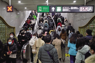 2月13日,地铁7号线磁器口站,乘客沿着电动扶梯和楼梯缓慢前行.