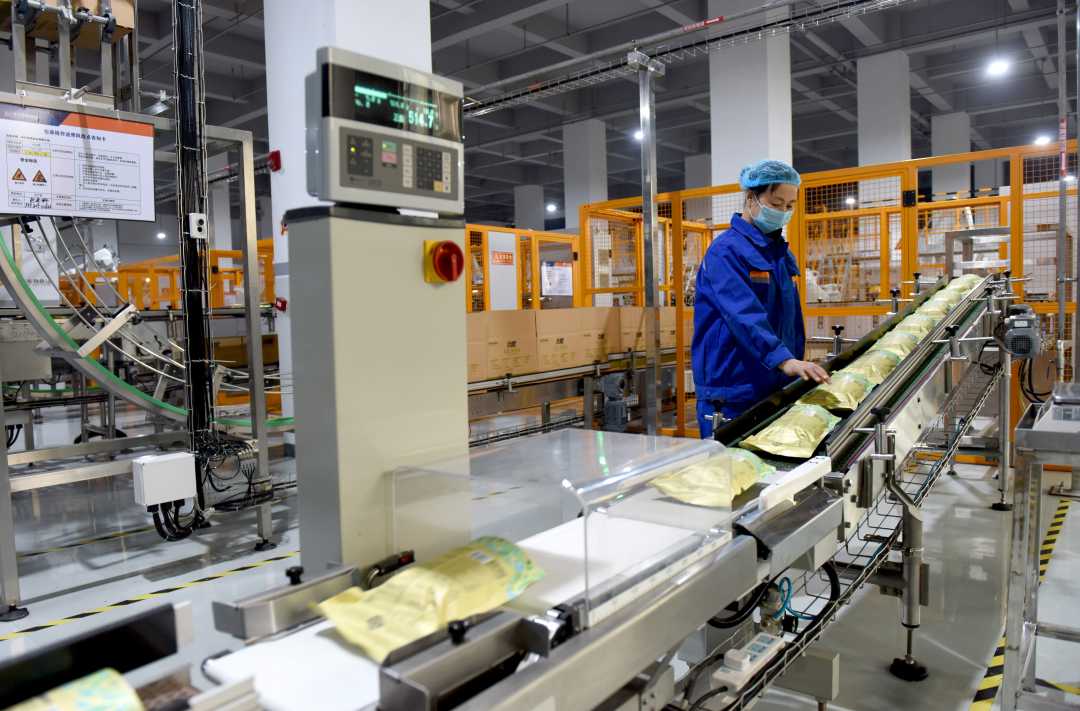 在邢台市南和区一家宠物饲料生产企业车间里,工人正在包装生产线上