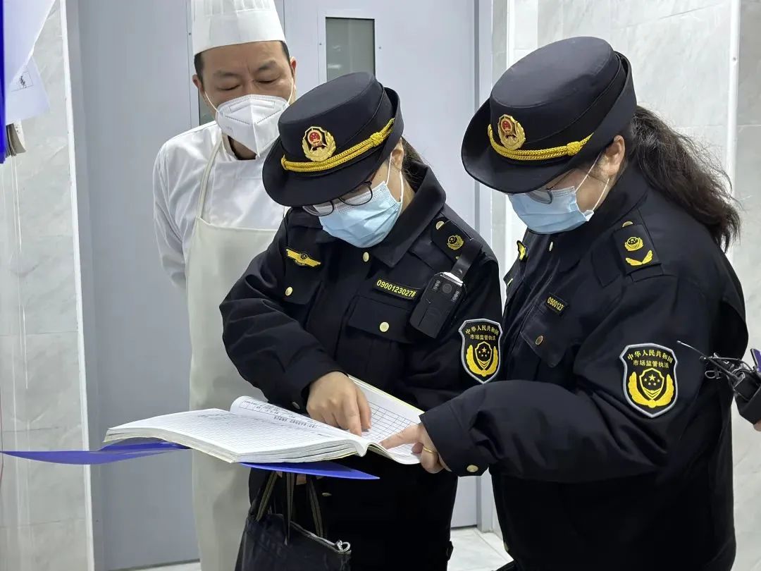 金山区市场监管局执法人员正在漕泾中学检查采购食品的索证索票和台账