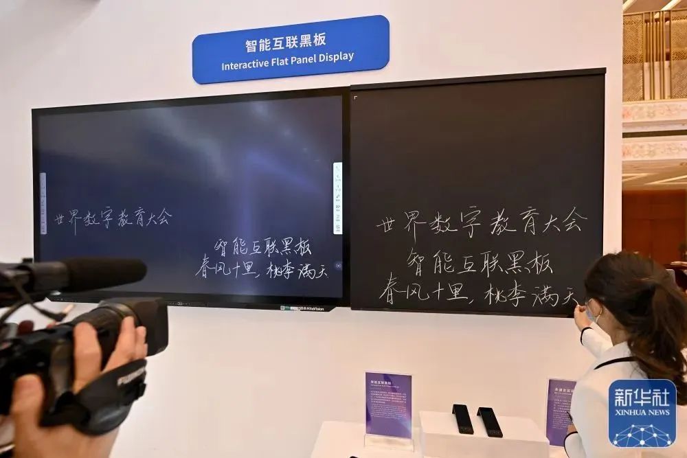 一名工作人员展示智能互联黑板.(新华社记者&nbsp;李鑫&nbsp;摄)