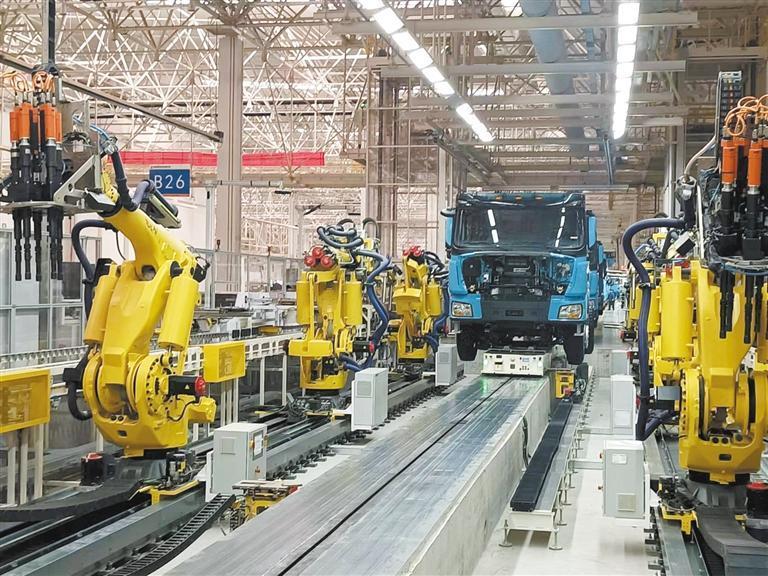 2月13日,在陕汽重卡扩能基地总装厂自动装配线上,工业机器人正在为
