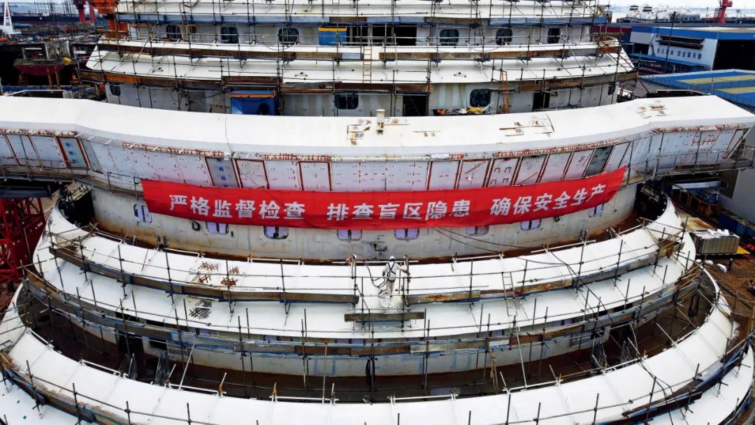 2022年8月3日，在中国船舶集团旗下上海外高桥造船有限公司，工作人员在中国首制大型邮轮外部进行施工。摄影/本刊记者 殷立勤