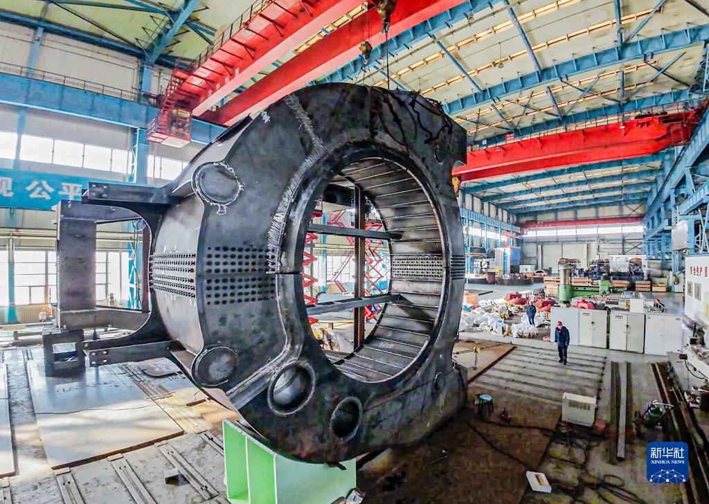 2月18日，工人在位于辽宁省沈阳市的北方重工有限公司车间吊装零部件（无人机照片）。