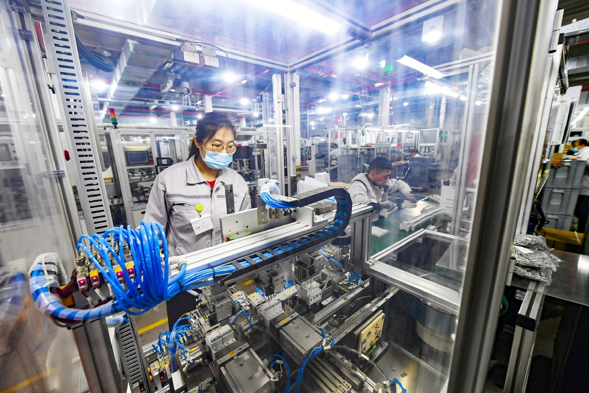 北元电器生产车间内,数条生产线有序运行.图为工人操纵机器.