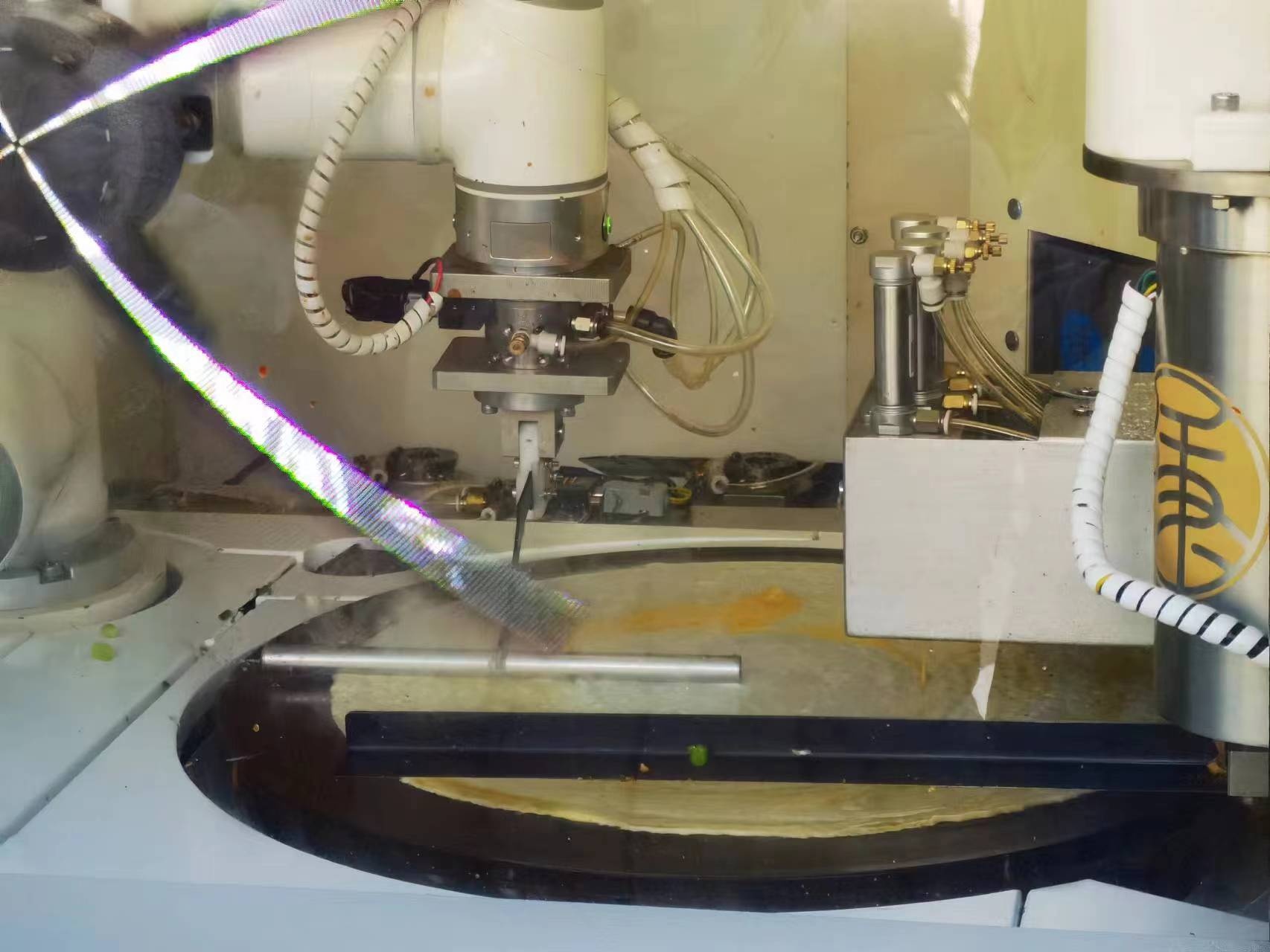 摊煎饼的每一个步骤,机器人都做得有条不紊.