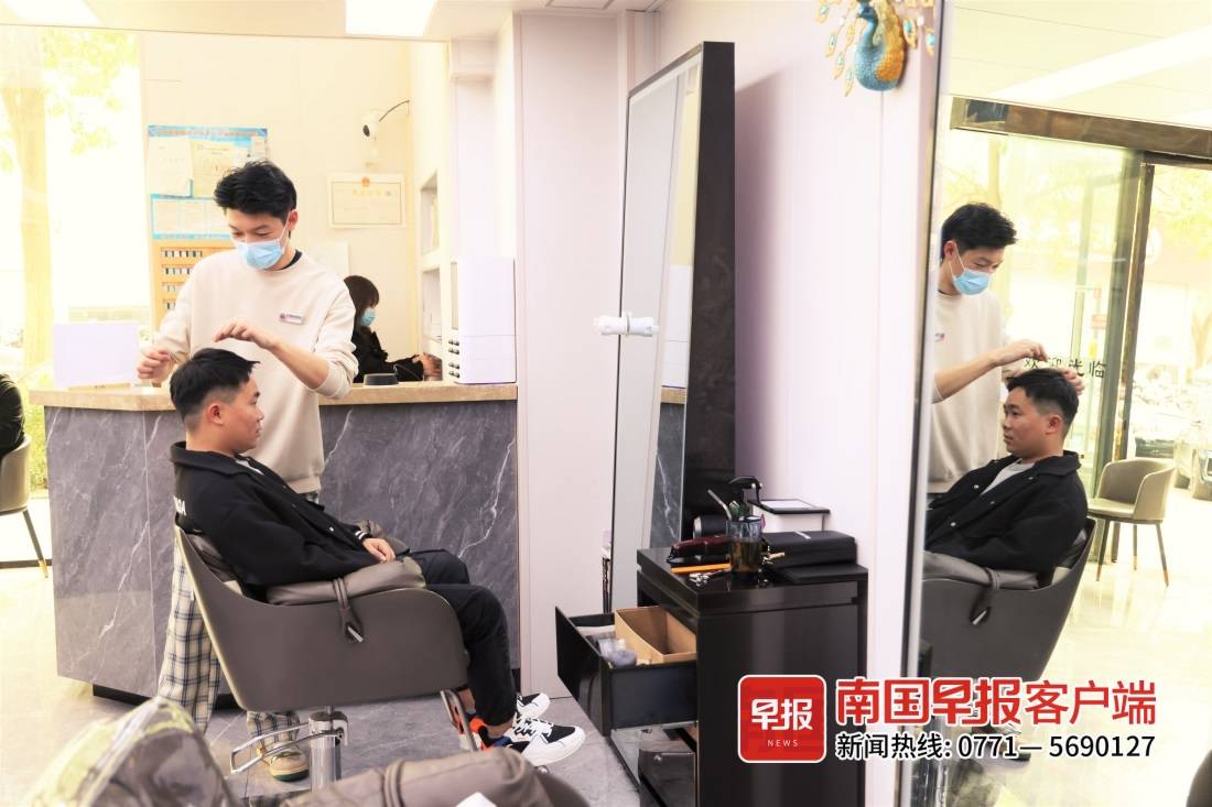 2月21日中午,南宁市民主路附近一家美发店内,市民在理发.