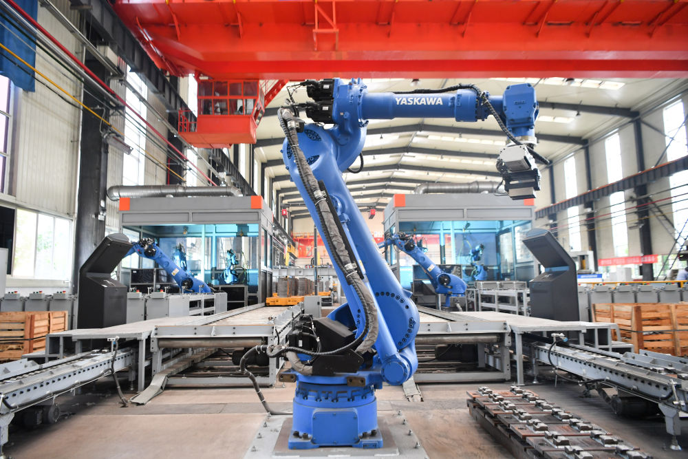 中铁宝桥集团有限公司道岔分公司生产车间,工业机器人在生产线上工作.