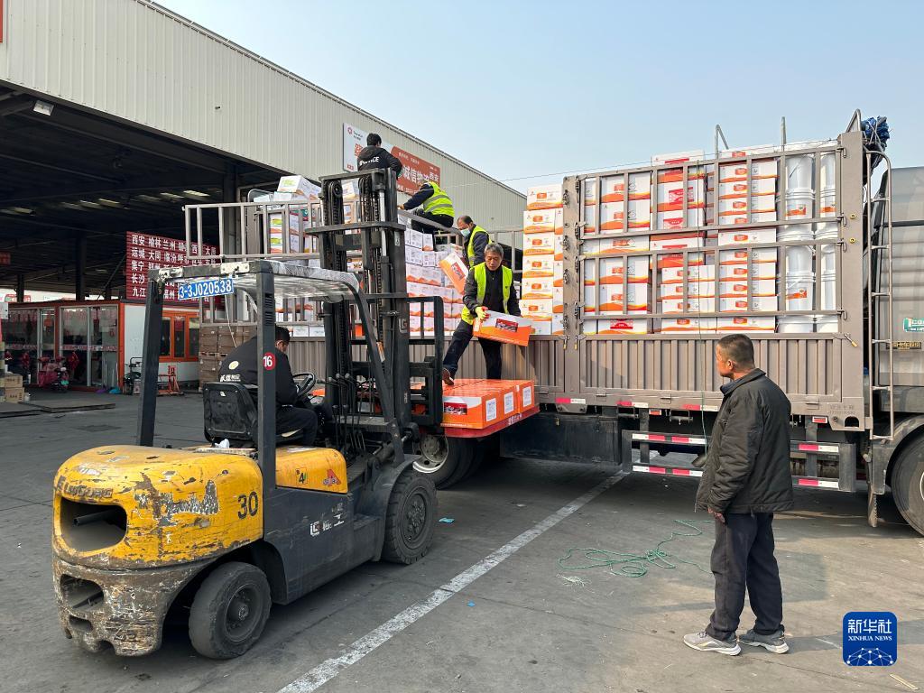 卸货区内叉车往来穿梭,工人们拿着货单挨个检查货物数量,到处都是一派