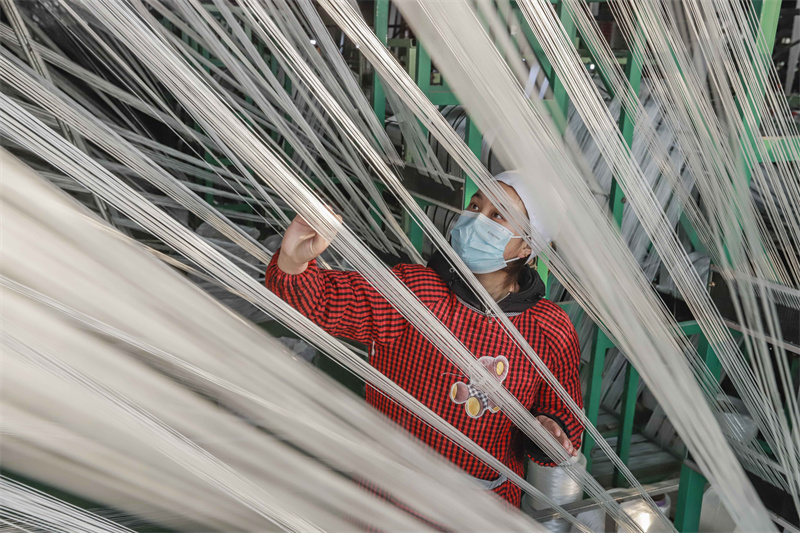 2023年2月22日,工人在河北省遵化市西下营满族乡化纤纺织企业车间工作