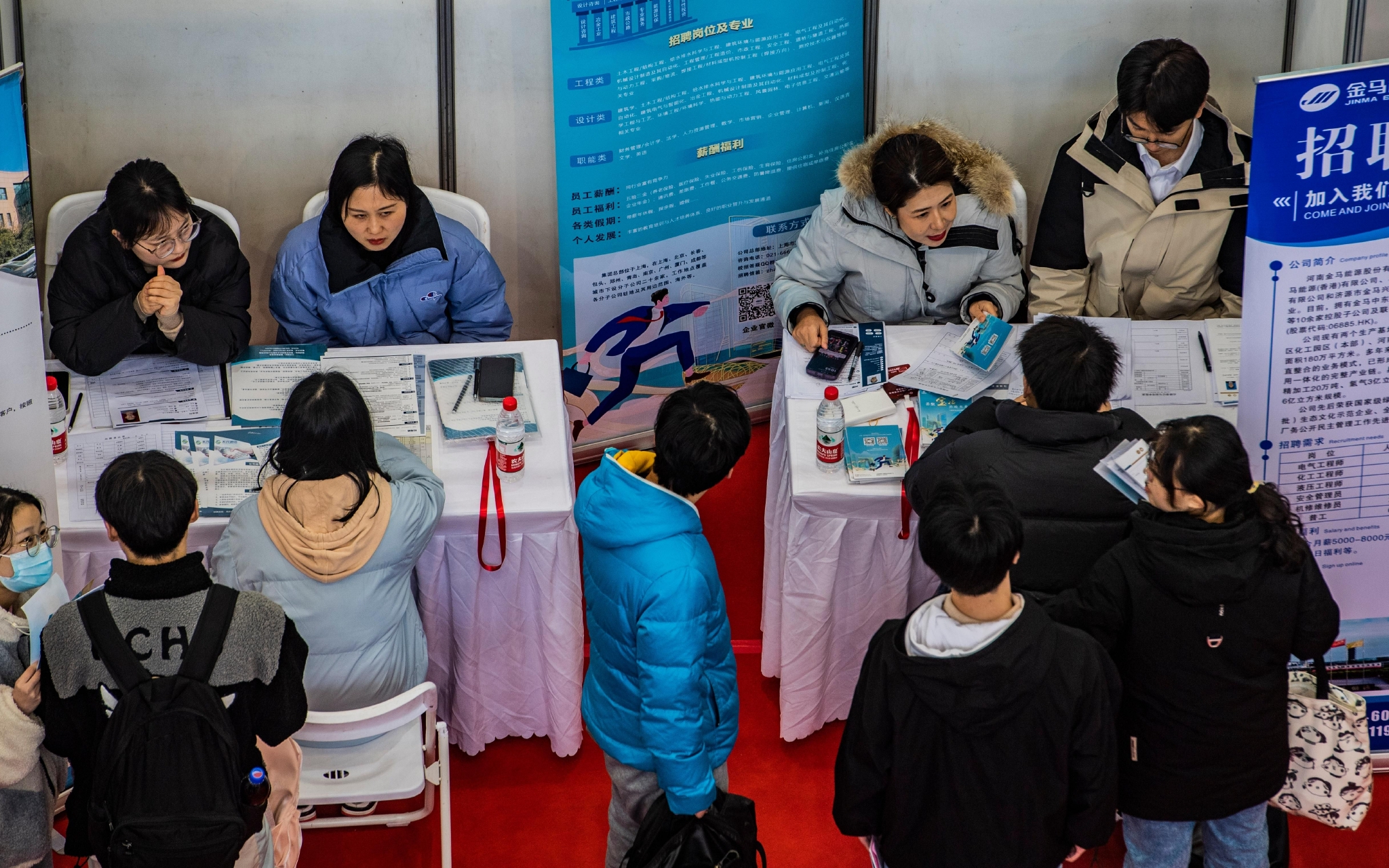 ▲资料图：2月16日，学生在西安建筑科技大学2023届毕业生春季就业洽谈会上与招聘单位洽谈。图/新华社