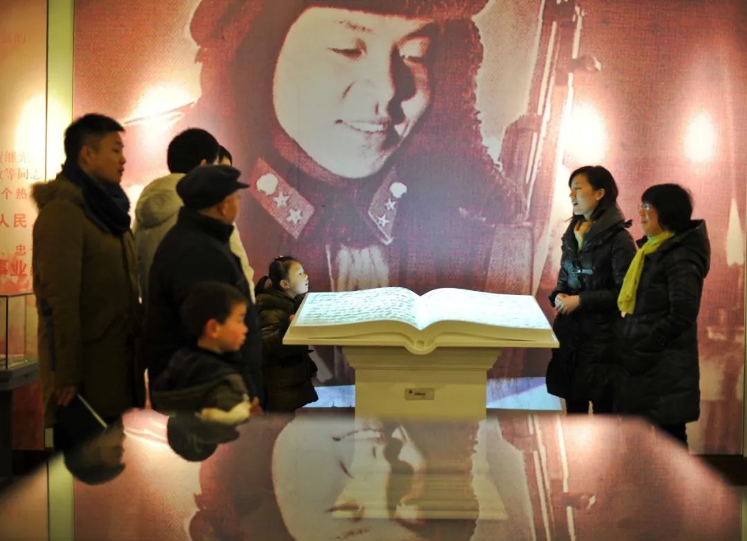 2012年2月18日，湖南长沙雷锋纪念馆母女讲解员谭荒芳（右一）和张璐琪（右二）在给参观者讲解。新华社记者 白禹 摄