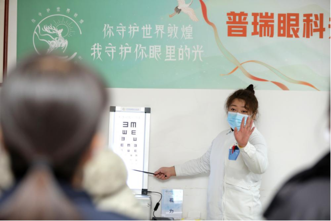 　　志愿者为工作人员检查眼睛