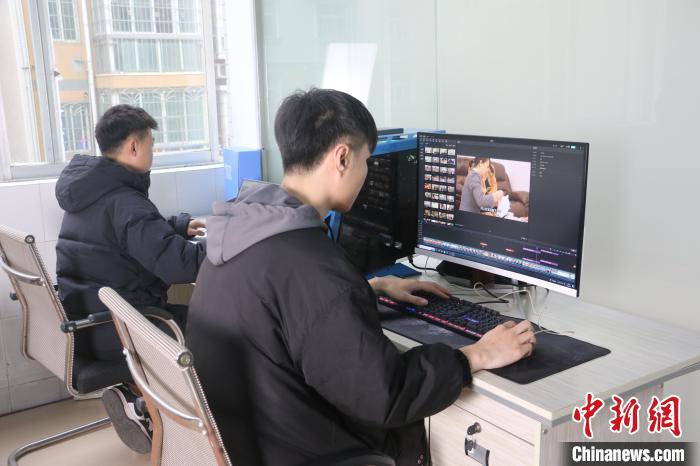 图为郭明浩（左）和他的同事在剪辑视频。林馨摄