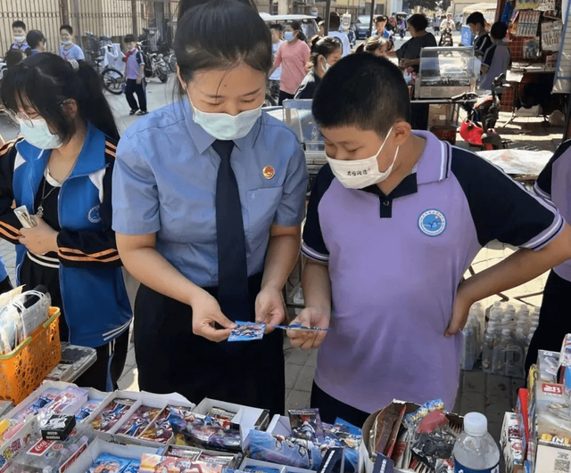 ↑河北省任丘市检察院检察官在校园周边商店对购买盲盒的学生进行引导，倡导其理性消费 图据检察日报