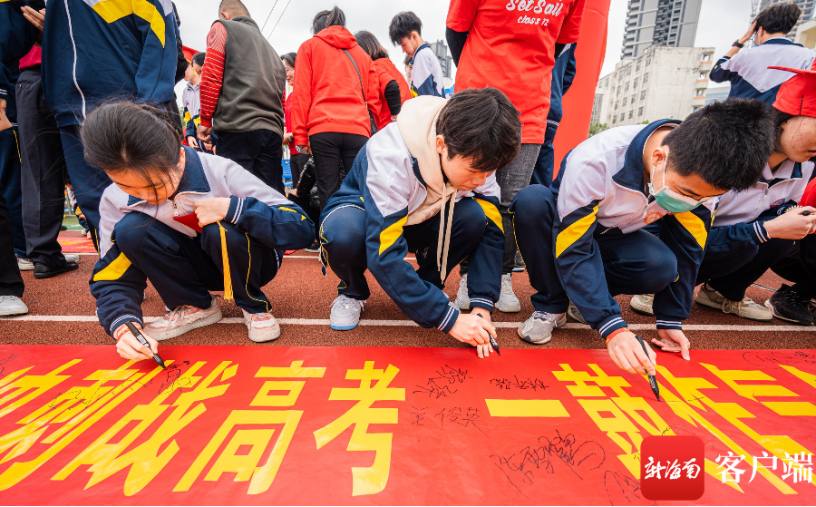 　　2月26日，在海口实验中学，学生在祝福横幅签名留念。记者 李昊 摄