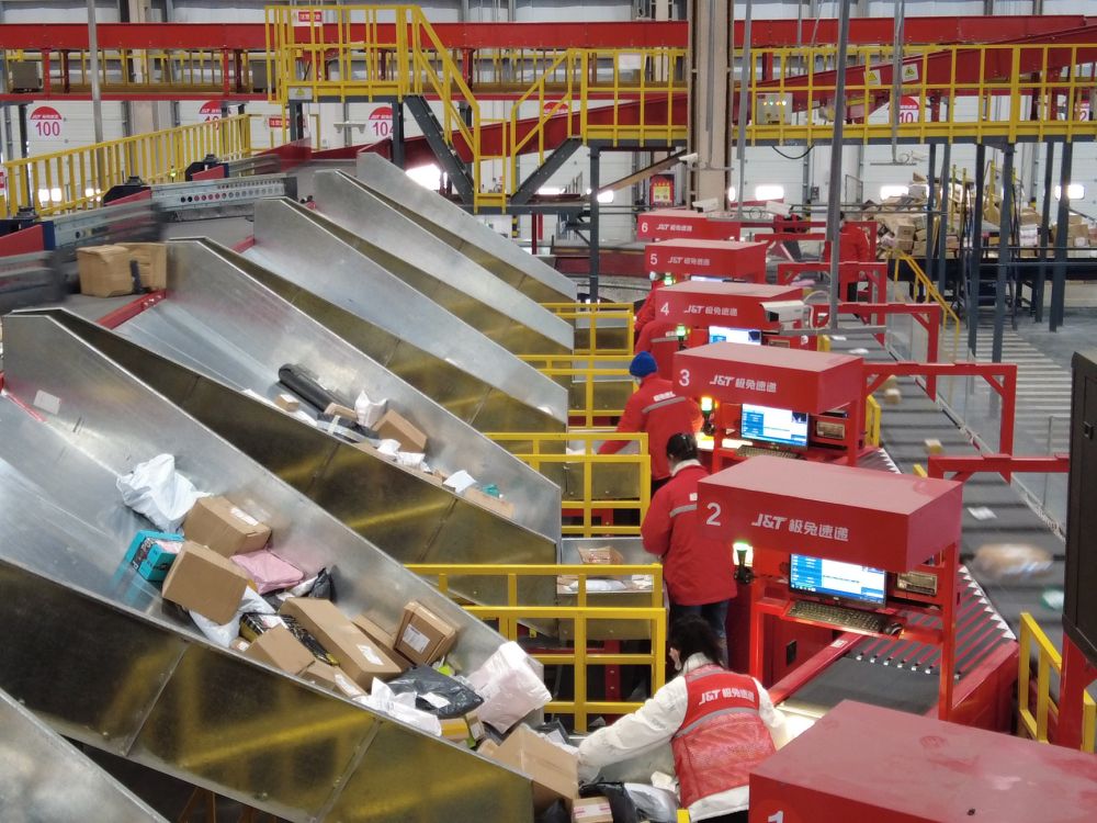 极速兔供应链管理有限公司分拣车间,工作人员在智能物流分拣线上忙碌