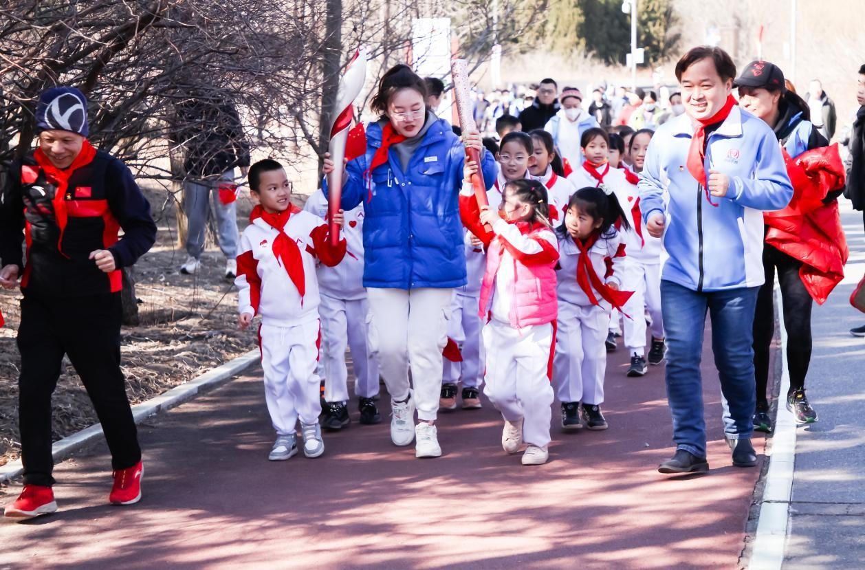 　　2008北京奥运会火炬和2022北京冬奥火炬在少先队员的手中传递