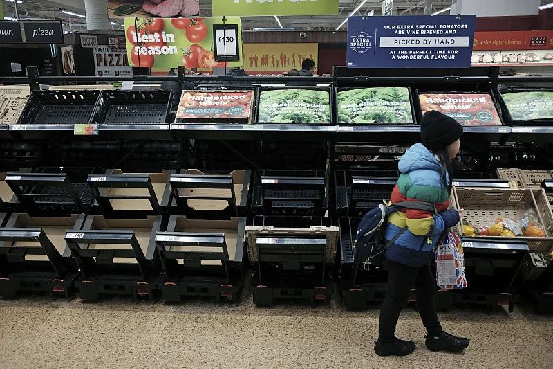 △当地时间2月25日，英国伦敦，一个女孩走过空荡荡的水果和蔬菜货架。
