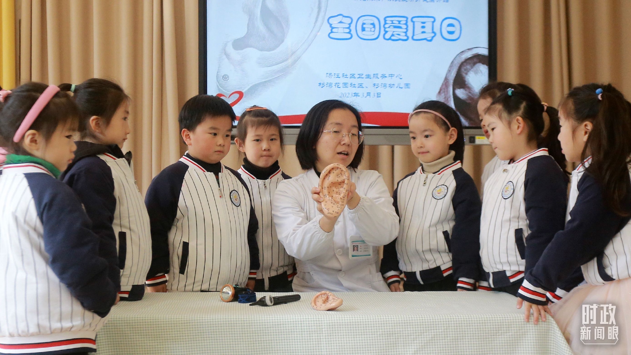 △2023年3月3日，全国爱耳日当天，江苏扬州一位社区医生正在为小朋友们讲解护耳知识。（图/视觉中国）