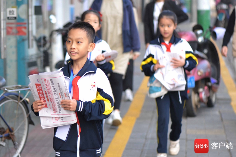 文昌市第三小学的学生走上街头成了"卖报小行家".记者 蒙健 摄