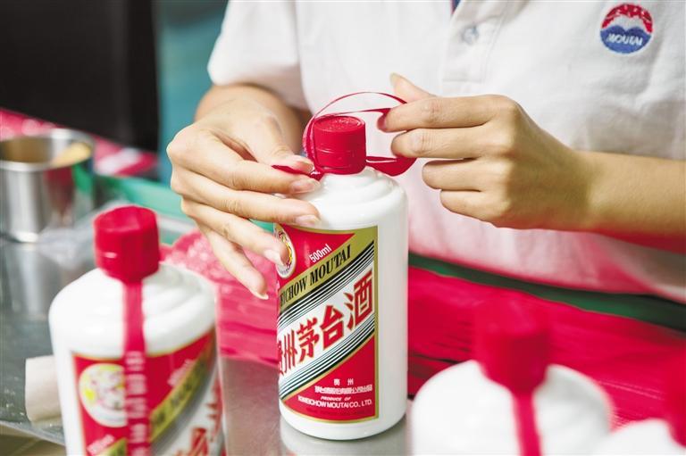 经过拧,套,打结等九个步骤,茅台酒标志性的红丝带被拴上瓶口.