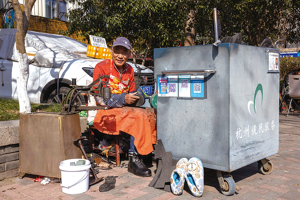 图为修鞋匠金荣祥在杭州市西湖区北山街道便民服务摊位修鞋. 江 汉 摄